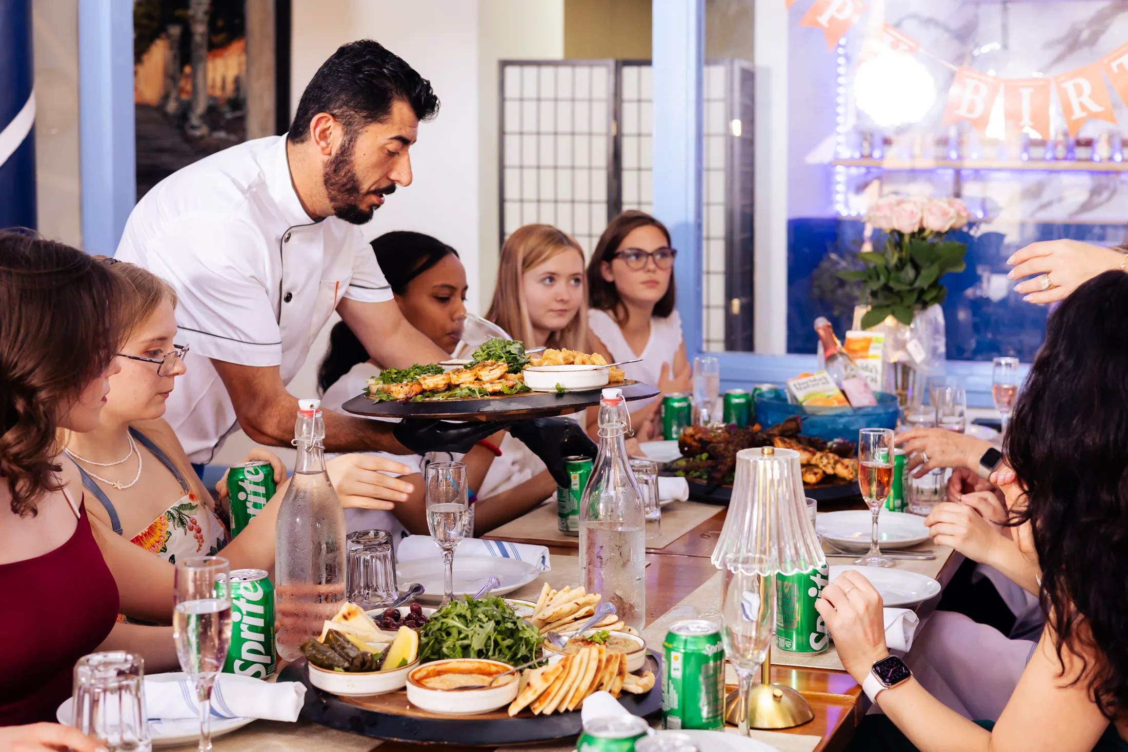A family-style platter being served at a full table